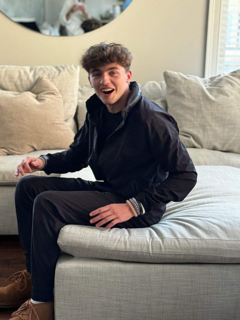 A teenager that is showing off some of his bracelets he received in the teen box from LoveJesus.